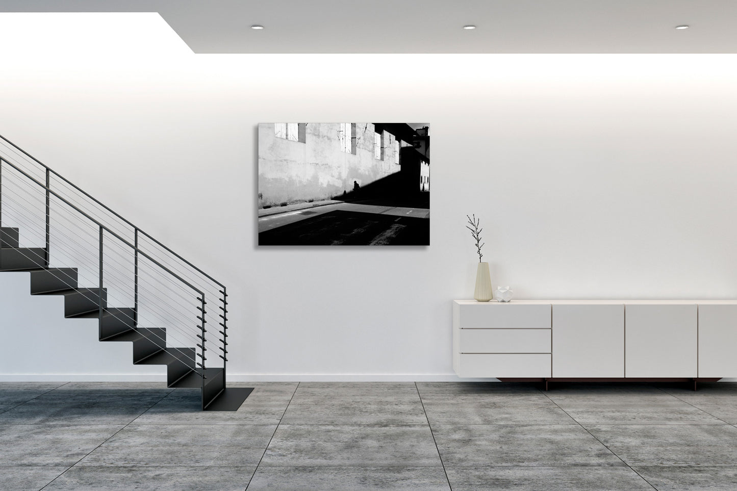 Collocata in un ambiente moderno, l’opera assume una presenza silenziosa ma decisa, suggerendo una riflessione sul confine tra presenza umana e spazio costruito. Positioned in a modern setting, the artwork takes on a quiet yet assertive presence, suggesting a reflection on the boundary between human presence and constructed space.