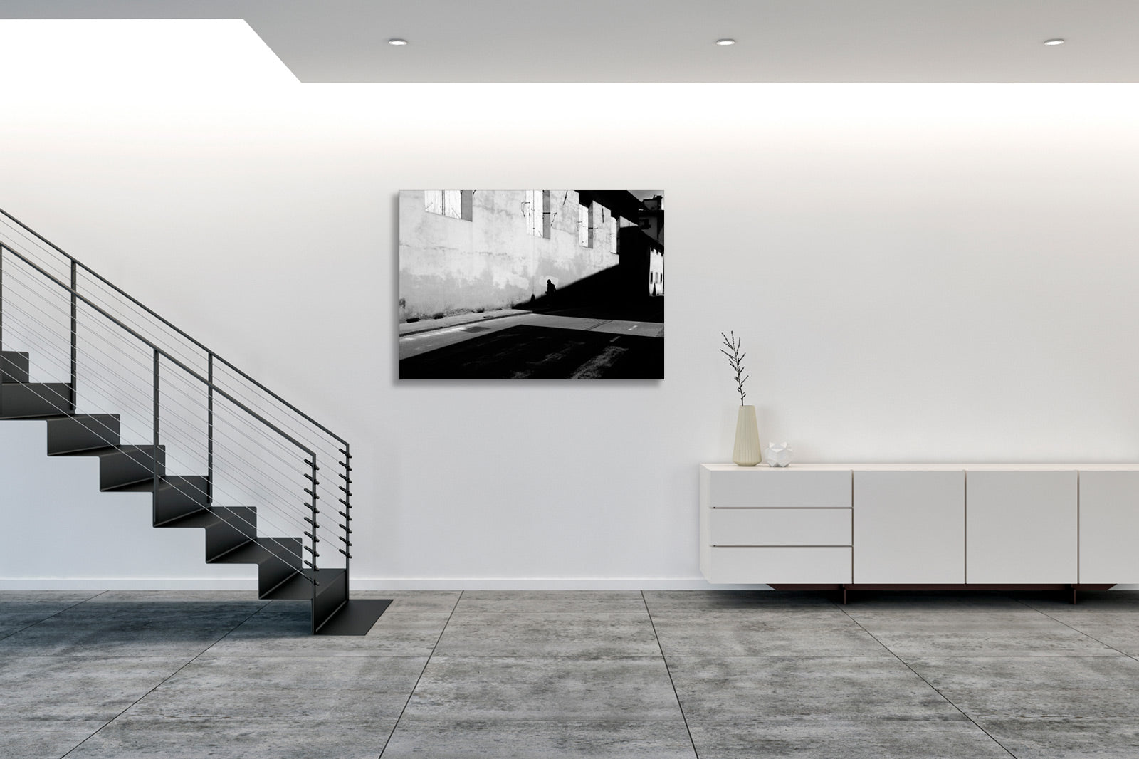 Collocata in un ambiente moderno, l’opera assume una presenza silenziosa ma decisa, suggerendo una riflessione sul confine tra presenza umana e spazio costruito. Positioned in a modern setting, the artwork takes on a quiet yet assertive presence, suggesting a reflection on the boundary between human presence and constructed space.